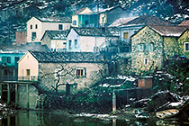 Snowy houses nearby lake
