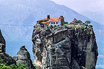 Monastery on top of rock in front of mountains