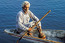 Old man smoking water pipe on shikara