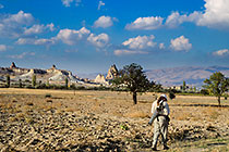 Paul walking in front of village