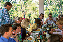 people sitting & eating around wedding table