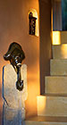 Cocagne house : african stone sculpture of man on stairs from lounge to dining