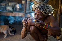 bushman smoking near fire in kitchen
