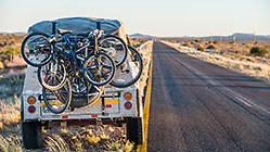 land cruiser with trailer & bicycles on side of road at sunset