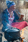 old busman woman smoking cigarette in open kitchen