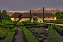 visitor center + clouds on Hottentots-Holland mountains after sunset