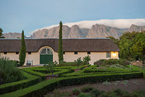 visitor center + clouds on Hottentots-Holland mountains after sunset