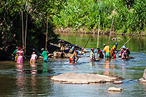 people panning sand for gold in river