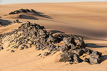 black rocks on sand dunes