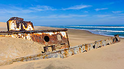shipwreck in sand along coast