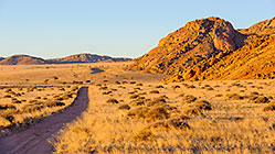 farm road along mountains at sunset