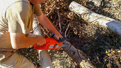 Paul cutting wood damaged by fire