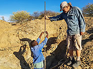 Paul & Sedney measuring level in excavated trenches for house foundation