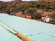 Lisa checking Sedney & Rodney laying insulation over house roof
