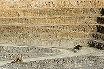 90 T truck driving down into pit & excavator driving up