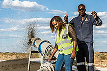 Monika Shipanga & field assistant near cyclone sprayer on tailings