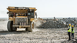 Monica Shipanga with driver & 90 T truck offloading rocks on top of waste pile