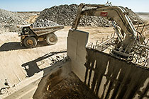 90 T truck offloading graded rocks into crusher