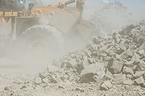front loader loading graded rocks to be offloaded at crusher