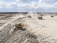 bulldozer & 90 T trucks offloading rocks on top of waste pile