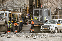 workers repairing drill of drilling machine in pit