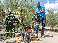 environmental field assistants taking borehole water sample