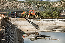 arsenic waste site | workers near water bassin