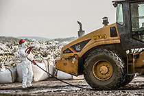 arsenic waste site | worker water cleaning roller compactor