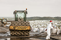 arsenic waste site | worker water cleaning roller compactor