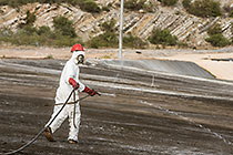 arsenic waste site | worker moving water sprayer