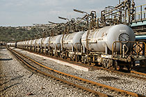 worker walking along railway | train of wagons containing sulphuric acid