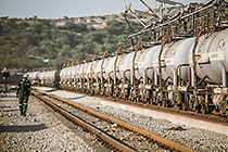 worker walking along railway | train of wagons containing sulphuric acid