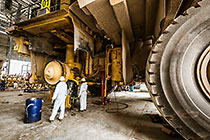 mechanics repairing wheel brake cylinder on 320T truck in workshop