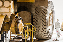 mechanics repairing wheel brake cylinder on 320T truck in workshop