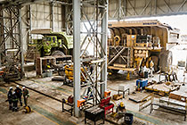mechanics repairing 320T trucks in workshop