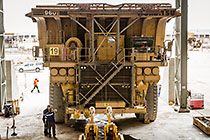 mechanics in front of 320T trucks in workshop