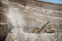 rope showel loading rocks into 320T truck in pit