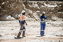 blasting team preparing borehole with explosive