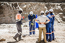 blasting team preparing borehole with explosive