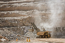rope showel loading rocks into 320T truck in pit