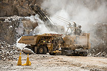 rope showel loading rocks into 320T truck in pit