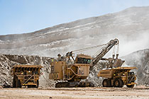 rope showel loading rocks into 320T trucks in pit