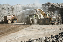 water spraying on digger loader loading 320T truck from stock pile