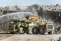 water spraying on digger loader loading 320T truck from stock pile