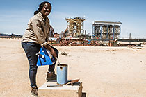environmental scrientist Kaarina Nkandi taking fresh water sample at boreole