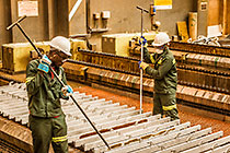 workers separating zinc sheets from receiving plates