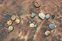 pebbles on red sand coast line