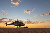 helicopter taking off at sunrise