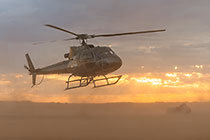 helicopter taking off at sunrise
