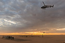 helicopter taking off with SkyTEM rig at sunrise